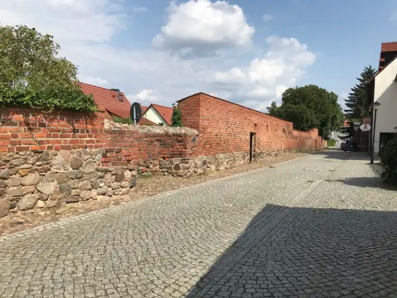 Historische Stadtmauer in Jüterbog mit gepflasterter Gasse bei der Mauritius-Apotheke